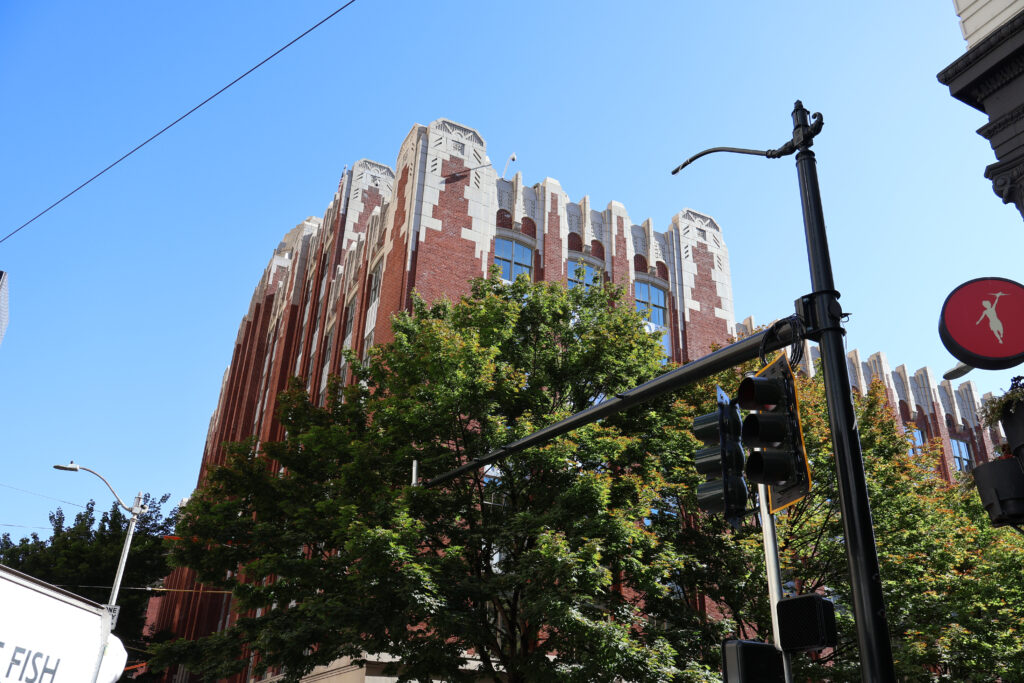 A tree and streetlight covering a brick building in downtown Seattle.