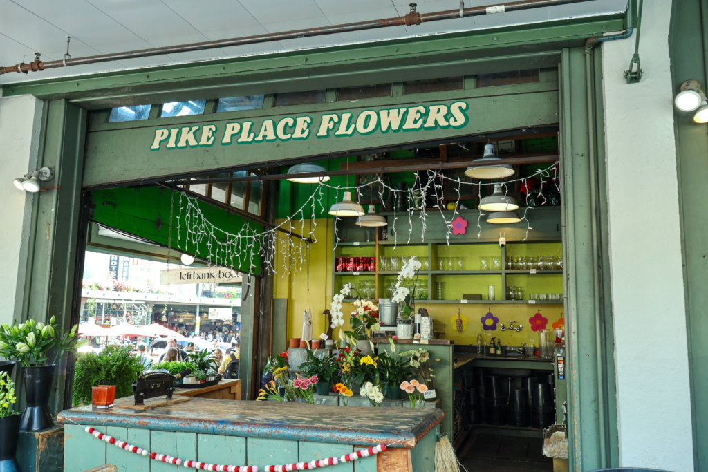 The green shopfront of Pike Place Flowers in in downtown Seattle.